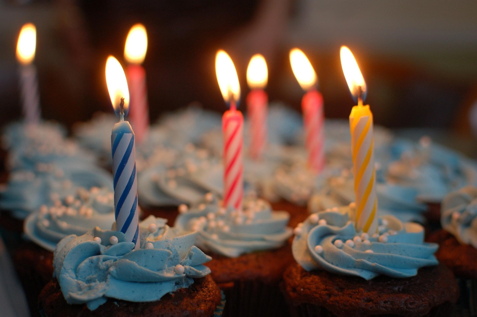 Várias velas acesas em cima de mini bolinhos
